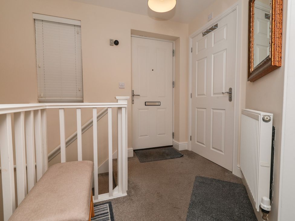 A hallway with a front door and staircase at Rails End in Whitby