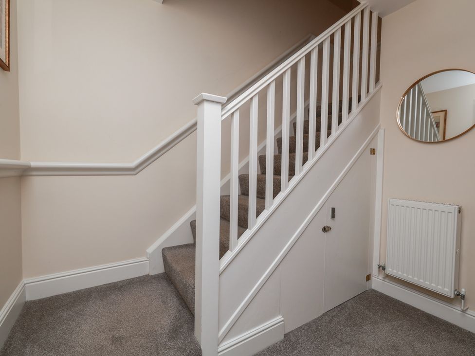 A staircase with a handrail and door at Rails End in Whitby