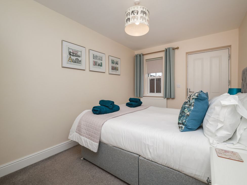 A bedroom with a bed and artworks on the wall at Rails End in Whitby