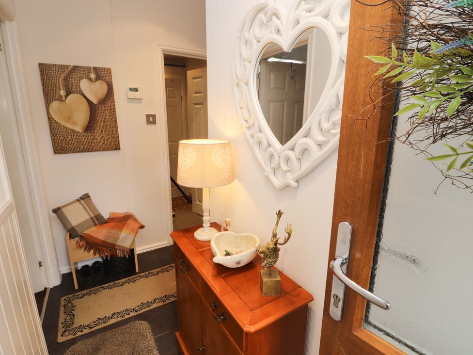 A hallway with a mirror and chest of drawers at Jodene Lodge, Redwood 2 in Bowness-On-Windermere