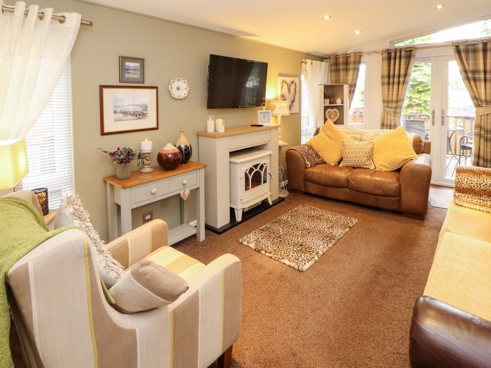 A living room with sofas and a television at Jodene Lodge, Redwood 2 in Bowness-On-Windermere