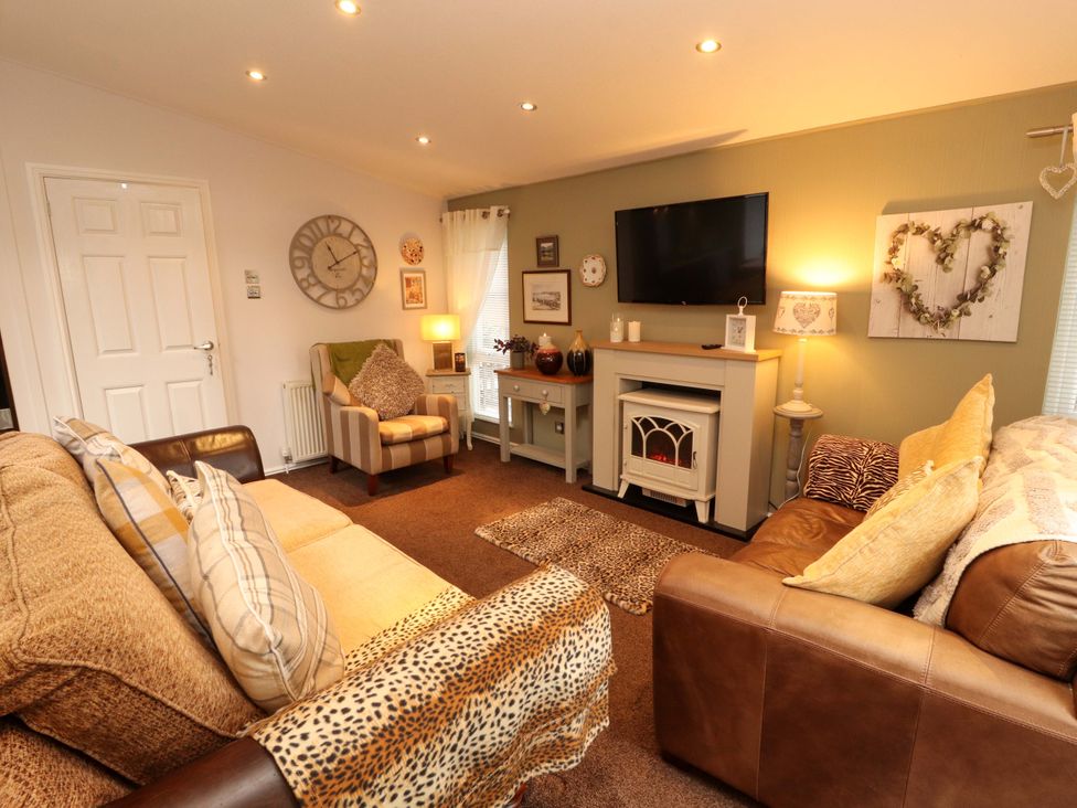 A living room with a sofa and armchair at Jodene Lodge, Redwood 2 Bowness-On-Windermere