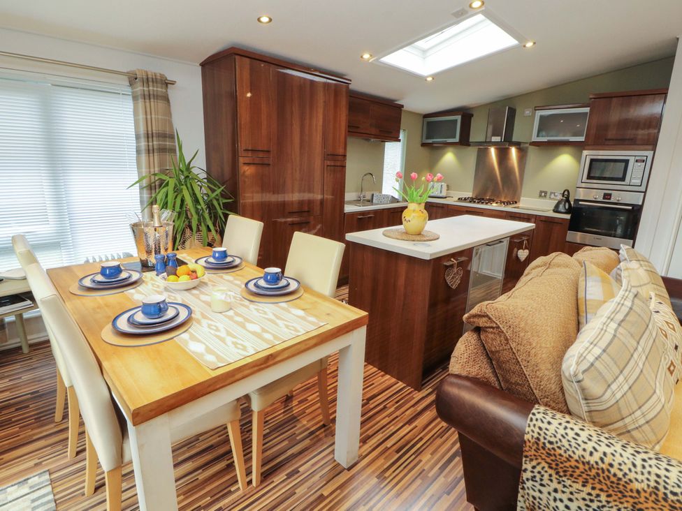 A kitchen with dining area and modern appliances at Jodene Lodge, Redwood 2 Bowness-On-Windermere