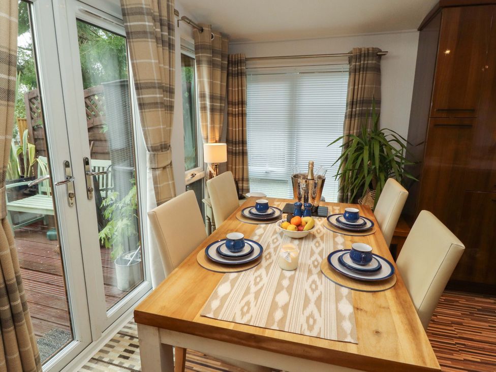 A dining room with a table set for a meal at Jodene Lodge, Redwood 2 Bowness-On-Windermere