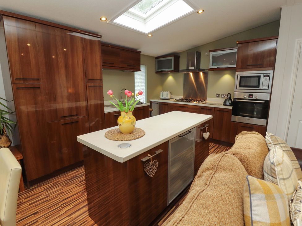 A kitchen with cabinets and appliances at Jodene Lodge, Redwood 2 Bowness-On-Windermere