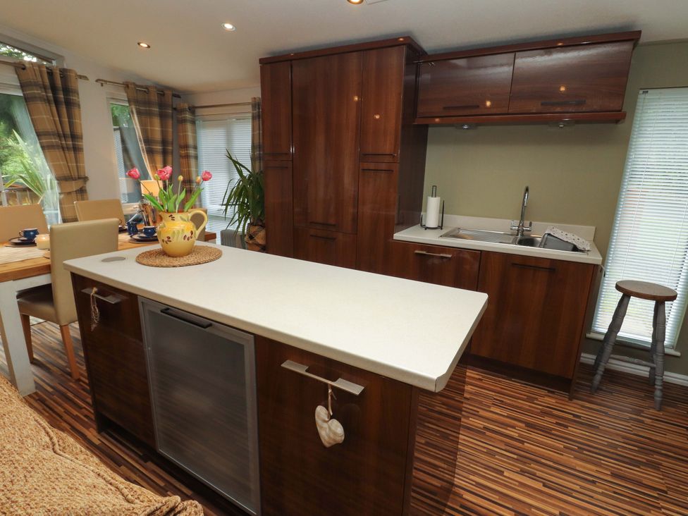 A kitchen with a sink and table at Jodene Lodge, Redwood 2 Bowness-On-Windermere