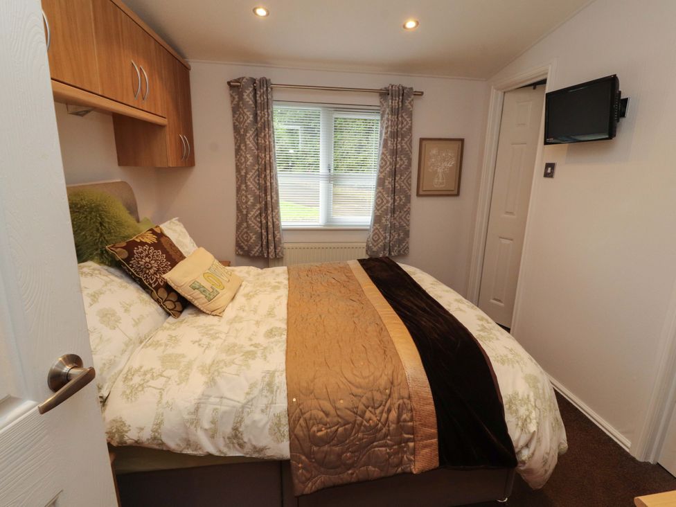 A bedroom with a bed and window at Jodene Lodge, Redwood 2 Bowness-On-Windermere