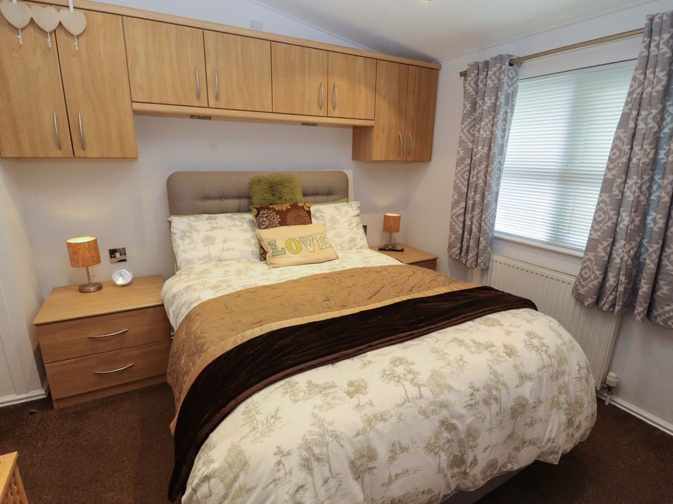 A bedroom with a bed and nightstand at Jodene Lodge, Redwood 2 Bowness-On-Windermere