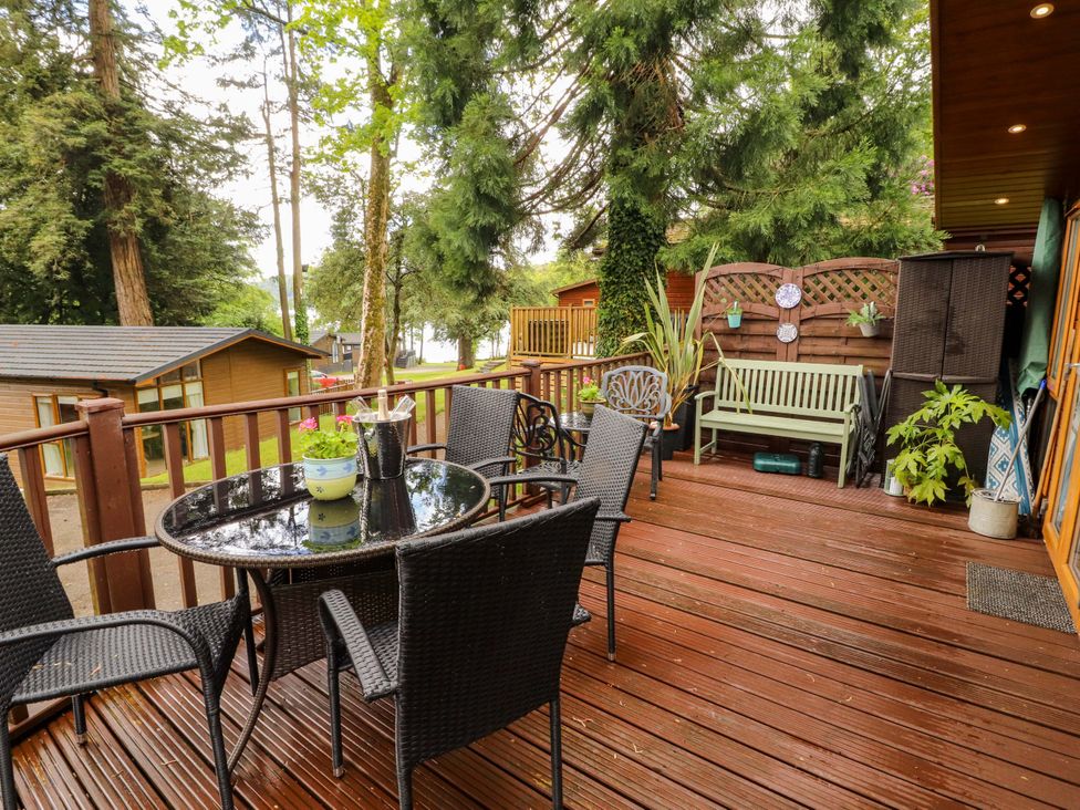 An outdoor patio with a table and chairs at Jodene Lodge, Redwood 2 Bowness-On-Windermere
