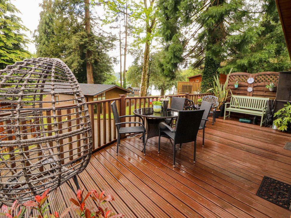 An outdoor area with a deck, table, and chairs at Jodene Lodge, Redwood 2 Bowness-On-Windermere