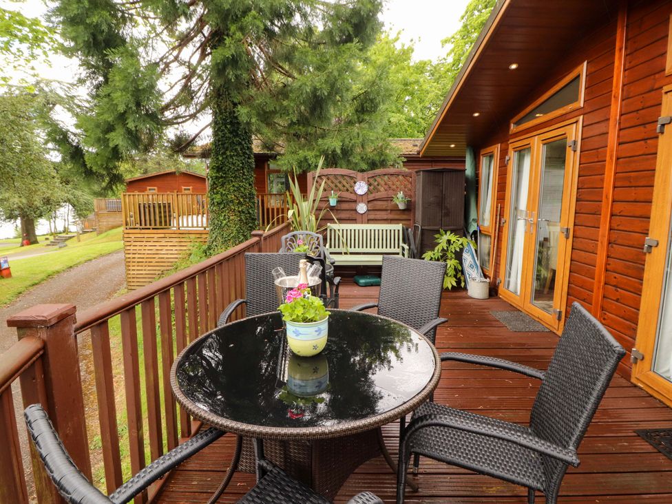 An outdoor seating area with a table and chairs at Jodene Lodge, Bowness-On-Windermere