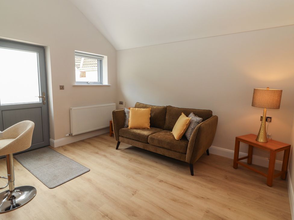 A living room with a sofa and lamp at 17 ROOSKA in Lisdoonvarna, County Clare