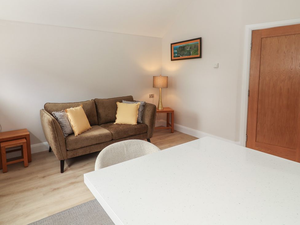 A living room with a sofa and lamp at 17 ROOSKA, Lisdoonvarna, County Clare