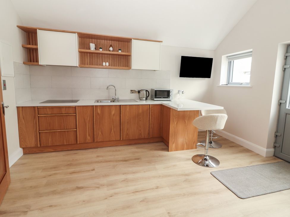A kitchen with cabinets, sink, microwave and kettle at 17 ROOSKA, Lisdoonvarna, County Clare