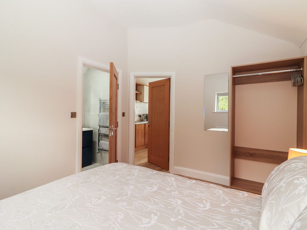 A bedroom with an open door leading to a kitchen at 17 ROOSKA, Lisdoonvarna, County Clare