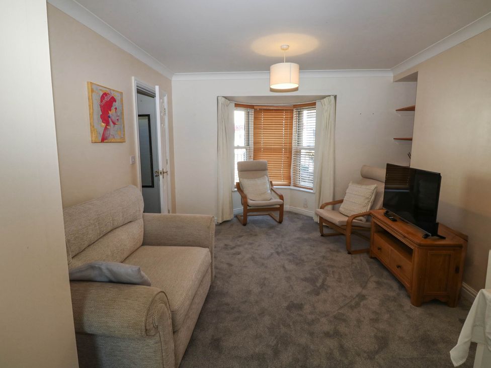 A living room with a sofa and television at Flat 1 in Kingsteignton