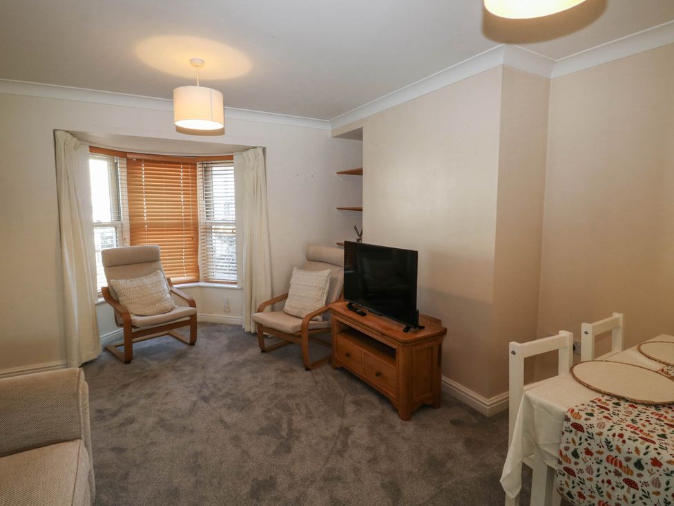A living room with furniture and a television at Flat 1 Kingsteignton