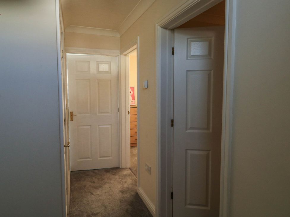 A hallway with several doors at Flat 1 in Kingsteignton