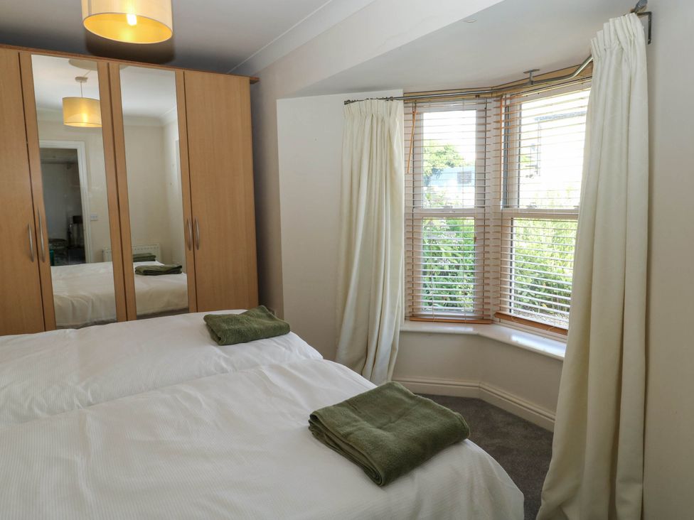 A bedroom with a bed and wardrobe at Flat 1 in Kingsteignton