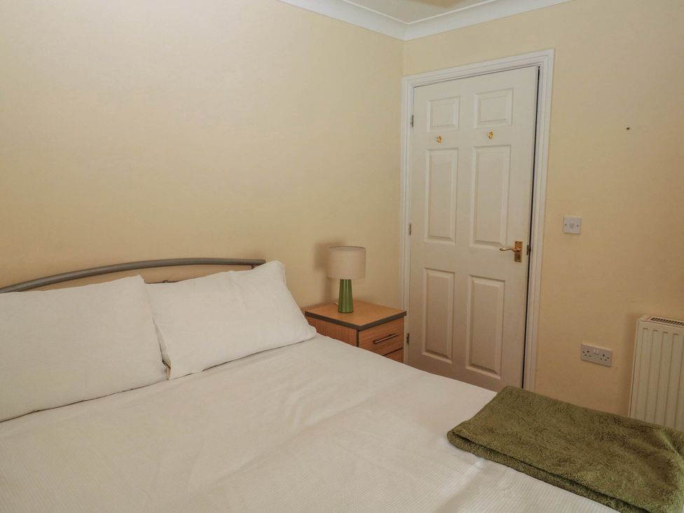 A bedroom with a bed and nightstand at Flat 1 in Kingsteignton