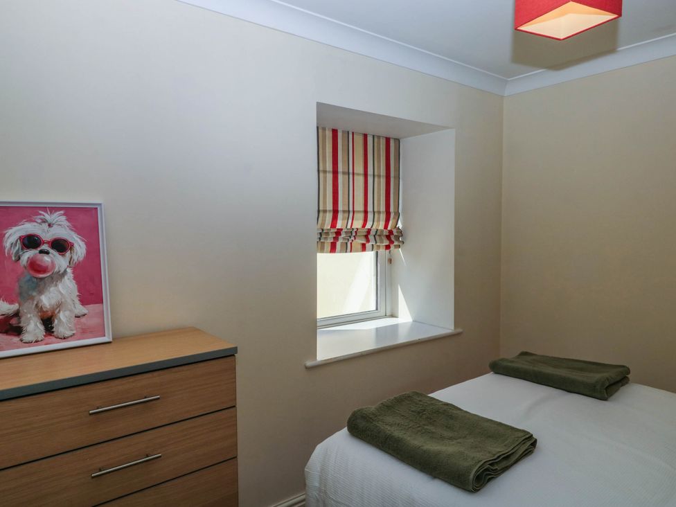 A bedroom with a photograph on the dresser at Flat 1 in Kingsteignton