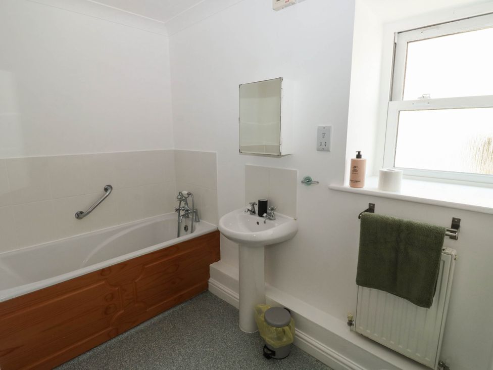 A bathroom with a sink and bathtub at Flat 1 in Kingsteignton