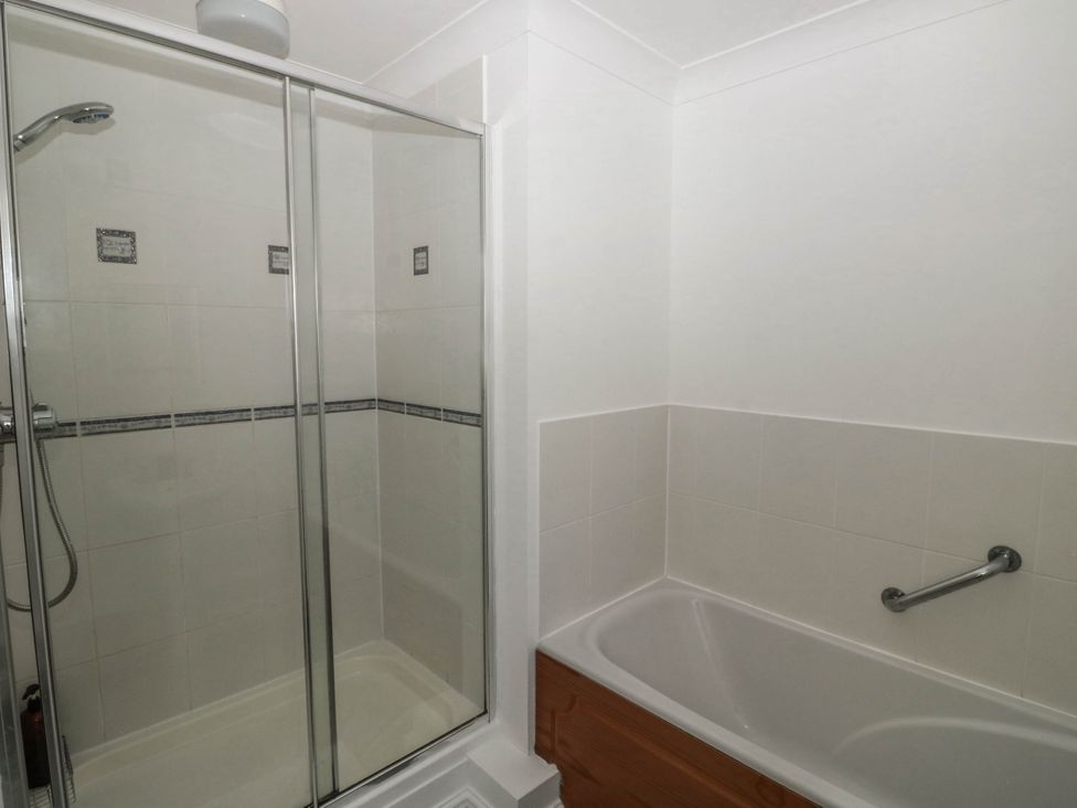 A bathroom with a shower and bathtub at Flat 1 in Kingsteignton