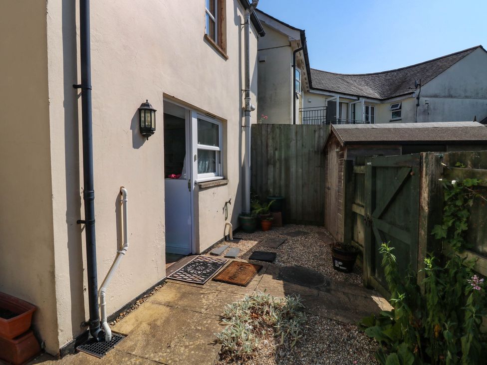 A garden with a pathway and potted plants at Flat 1 in Kingsteignton