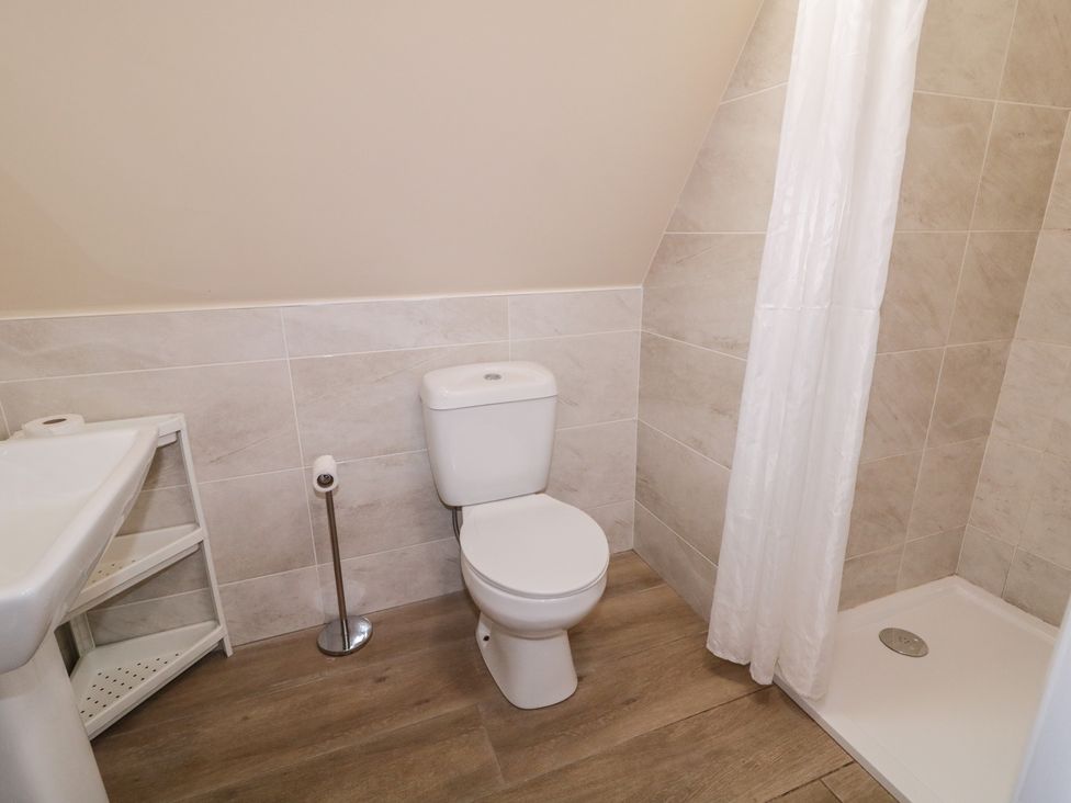 A bathroom with a toilet, sink, and shower at Cabin 1 Machaire Rabhartaigh, Gortahawk