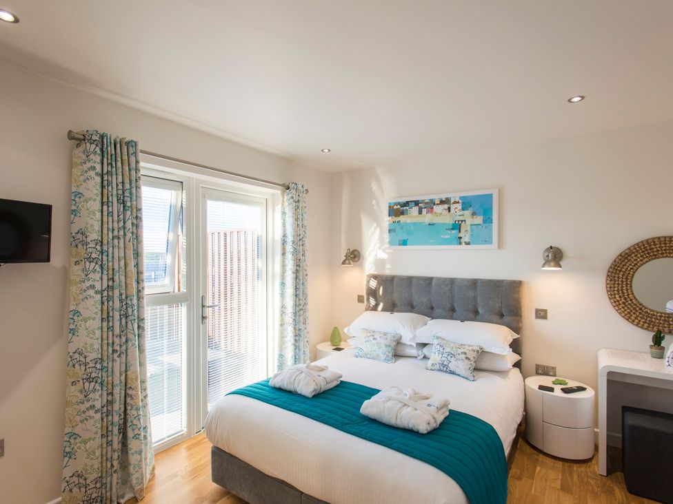 A bedroom with a bed and a television at Barbara in Portreath