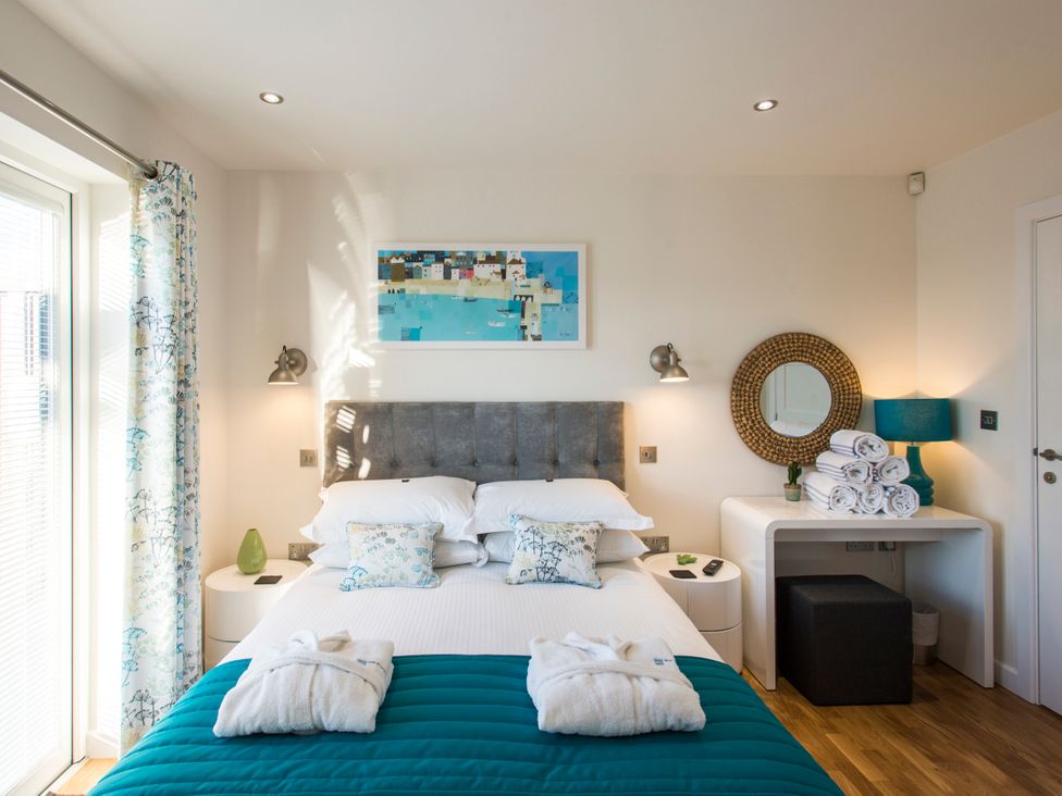 A bedroom with a bed and decorative pillows at Barbara in Portreath