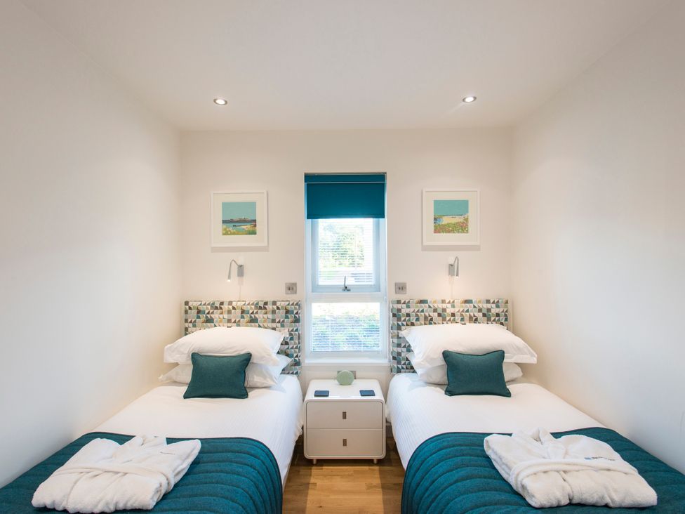 A bedroom with twin beds and a bedside table at Barbara in Portreath