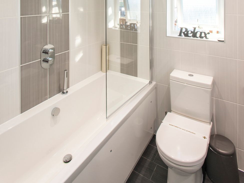 A bathroom with a bathtub, toilet, and shower at Barbara in Portreath