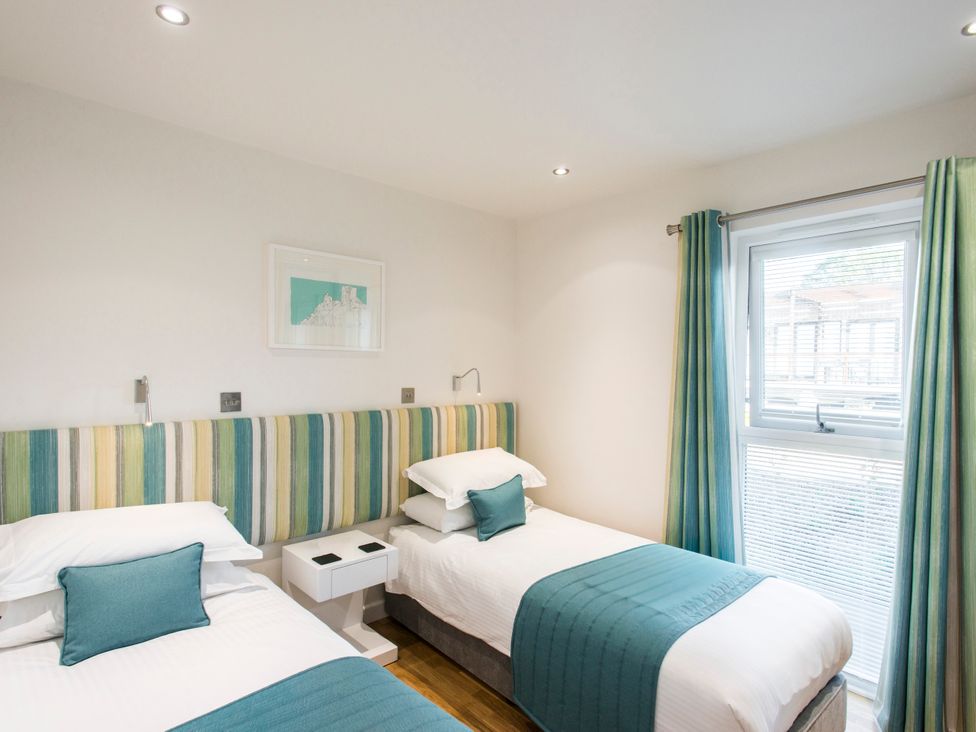 A bedroom with twin beds and a window at Barbara in Portreath