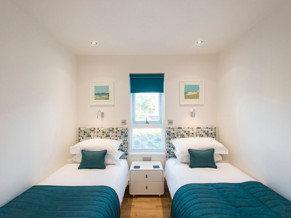 A bedroom with two beds and artworks on the wall at Barbara in Portreath