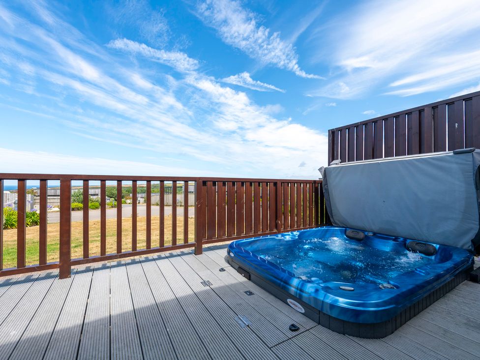 A hot tub on a deck with a railing at Barbara in Portreath