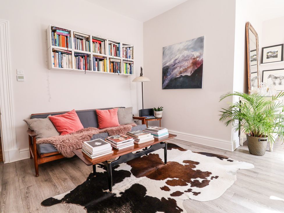 A living room with a sofa, bookshelf, and table at 34 Eaton Road in Chester