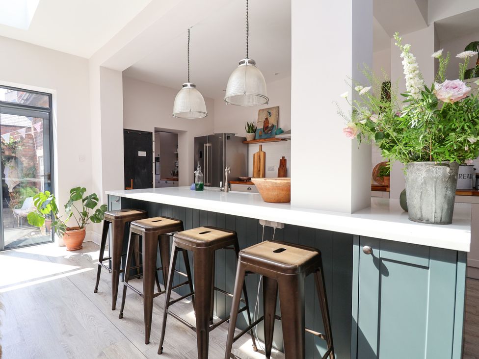 A kitchen with bar stools and flowers at 34 Eaton Road Chester