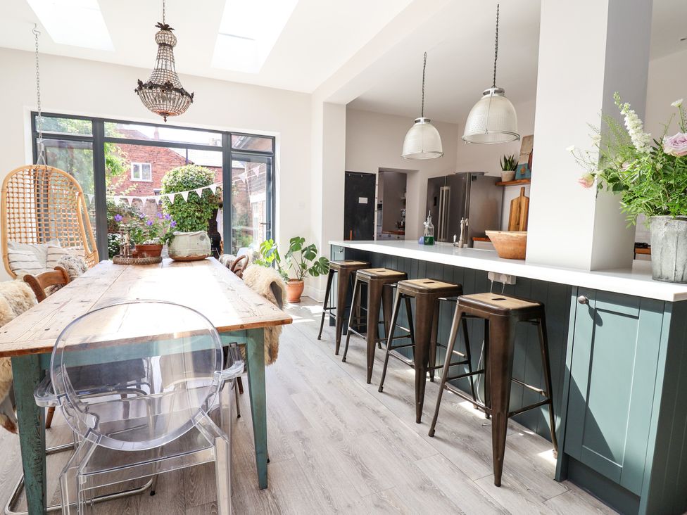 A dining room with a large table and bar stools at 34 Eaton Road Chester
