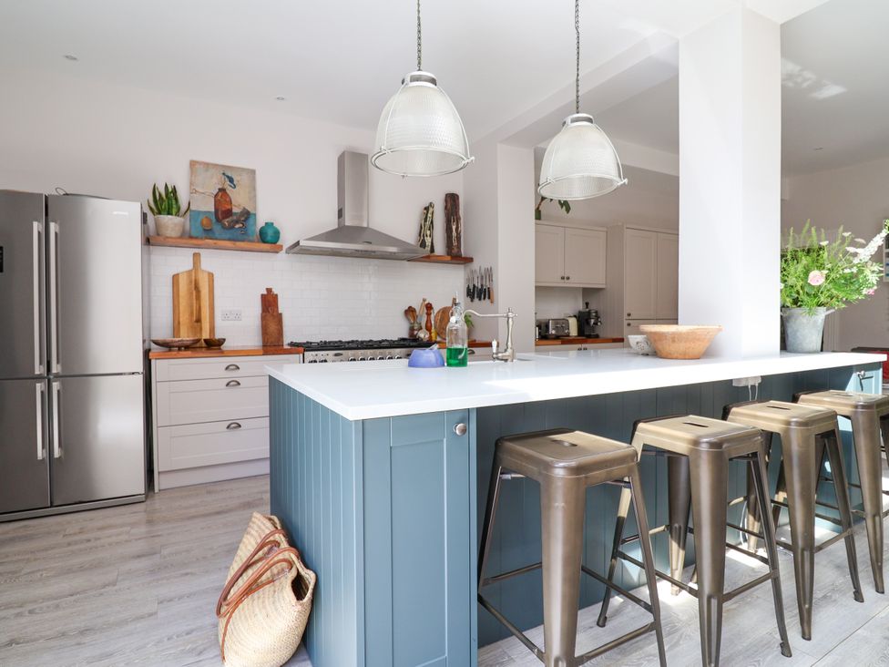 A kitchen with a countertop and bar stools at 34 Eaton Road Chester