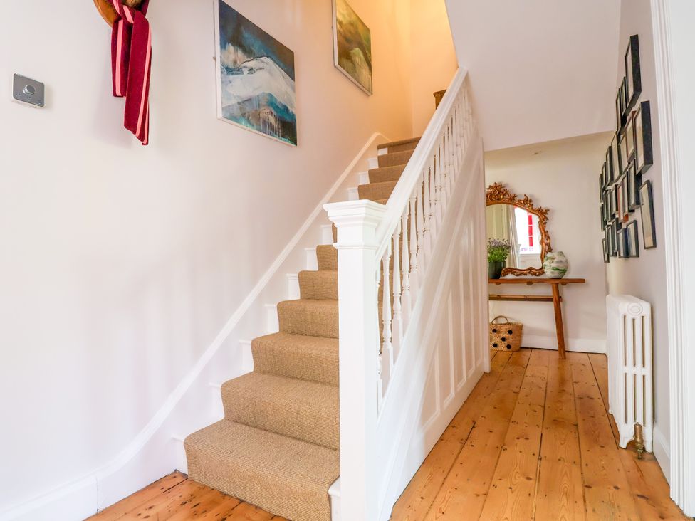 A hallway with a staircase and a mirror at 34 Eaton Road Chester