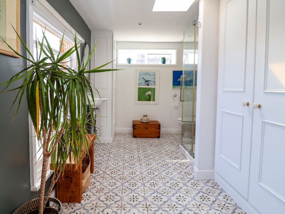 A bathroom with a shower, toilet, and plant at 34 Eaton Road in Chester