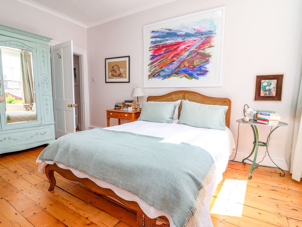 A bedroom with a bed, wardrobe, and artwork at 34 Eaton Road, Chester