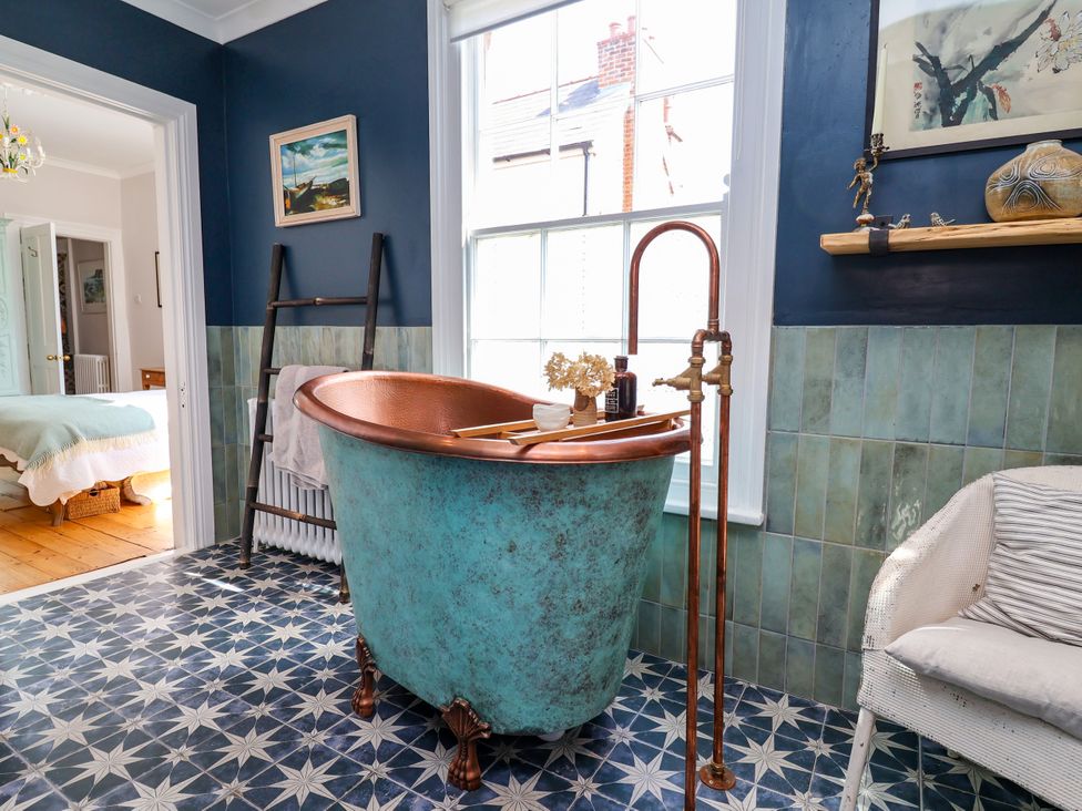 A bathroom with a bathtub and a chair at 34 Eaton Road in Chester
