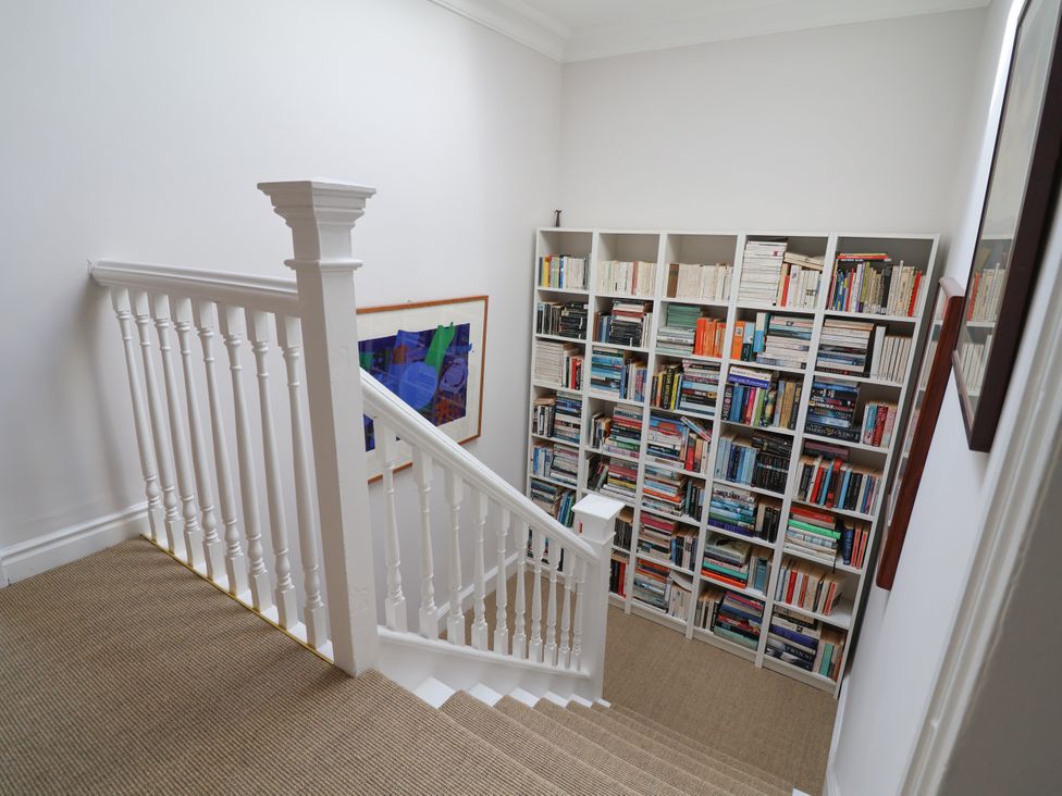 A staircase with a bookshelf filled with books at 34 Eaton Road Chester