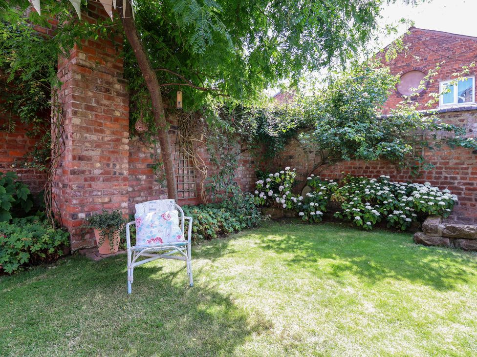 A garden area with a chair and flower bushes at 34 Eaton Road Chester