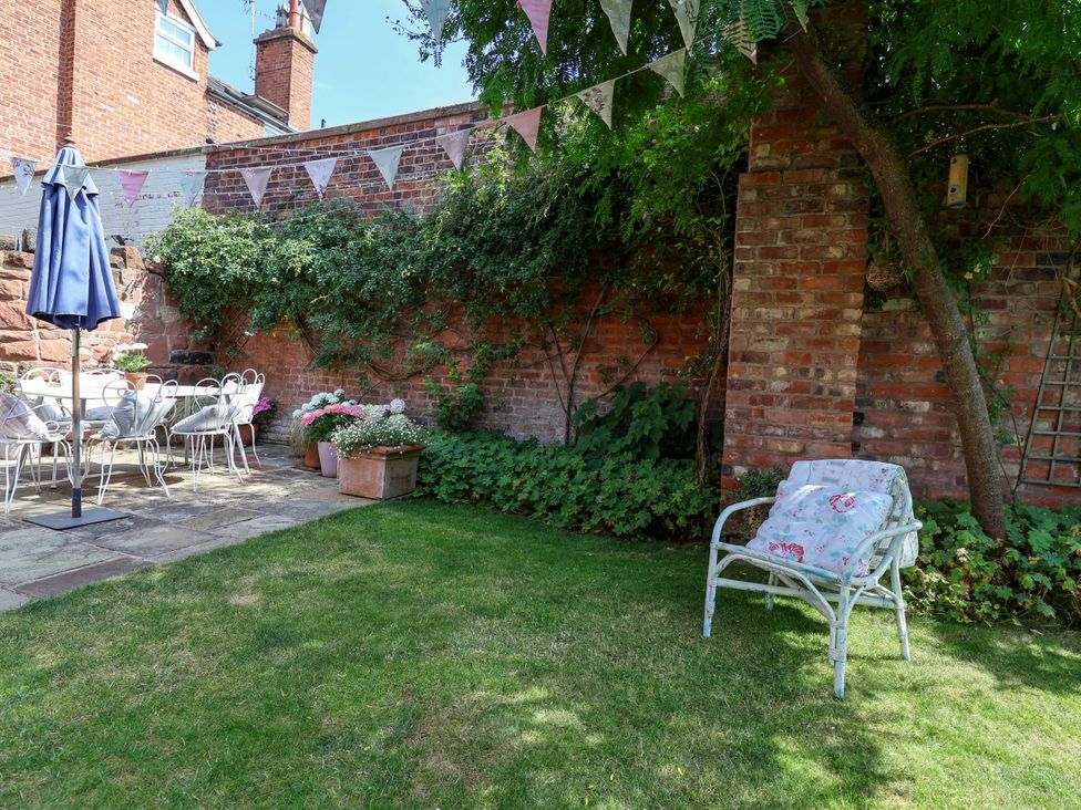 A garden with a table and chairs under an umbrella at 34 Eaton Road Chester