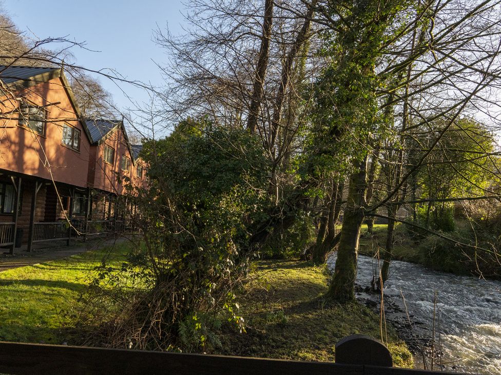 A view of houses near a river surrounded by trees at 3 bedroom Cabin (6 of 13) Port Talbot
