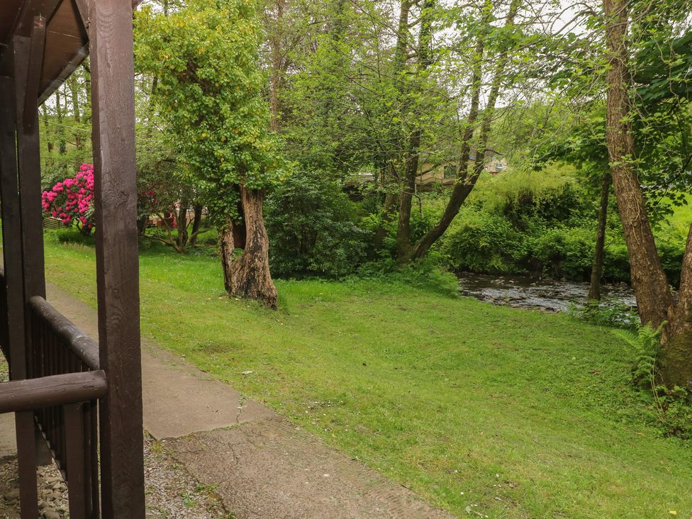 An outdoor area with a stream and flowers at Cabin No. 6 - Salt and Fern Cabins near Goytre