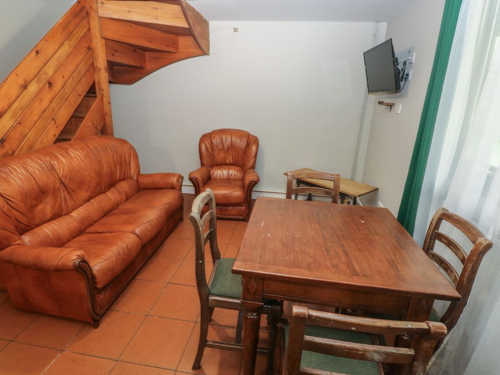 A living room with a sofa and dining table at Cabin No. 6 - Salt and Fern Cabins Goytre near Port Talbot